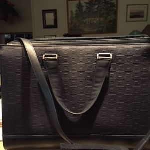 Navy Blue Tumi laptop bag with shoulder strap.